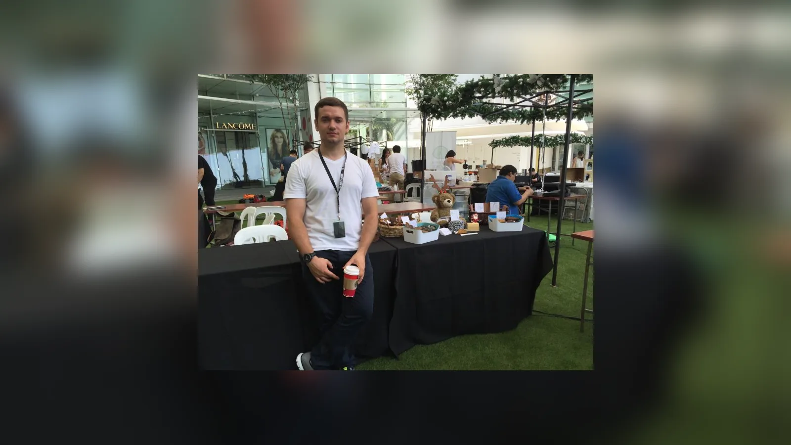 Maksim standing at a market stall inside a shopping centre
