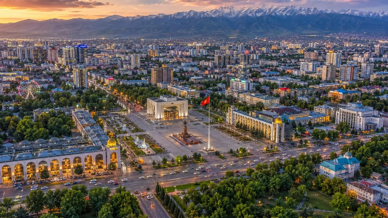 Панорама вечернего Бишкека с высоты: центральная площадь Ала-Тоо с флагштоком и Историческим музеем, кварталы города, снежные вершины Тянь-Шаня на горизонте